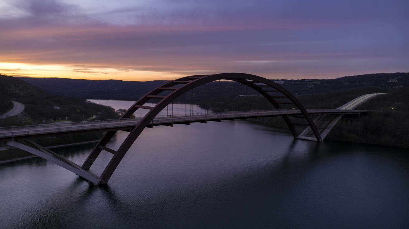 Pennybacker Bridge spanning Lake Austin at dusk with Texas Hill Country landscape.